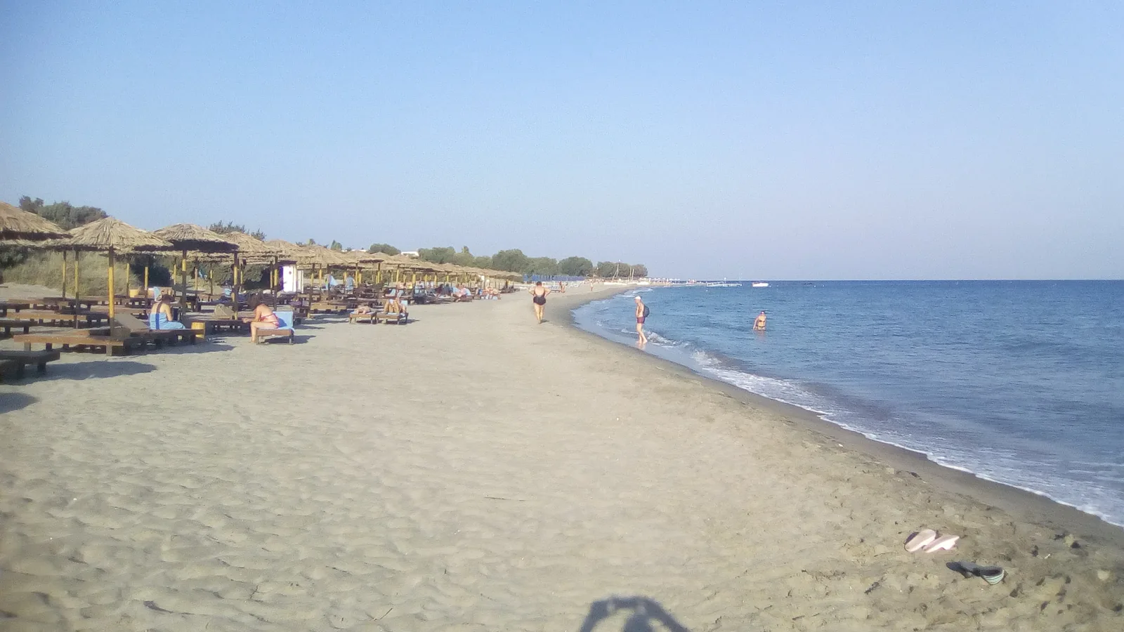 Kardamena beach on Kos island with thatched beach umbrellas and sunloungers — location of Mitsis Blue Domes all-inclusive resort