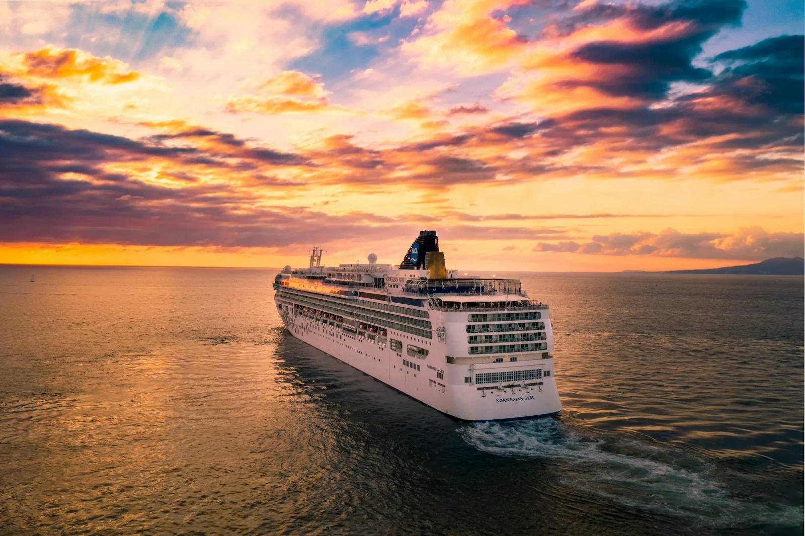 Large white cruise ship on a calm blue sea with clear sky