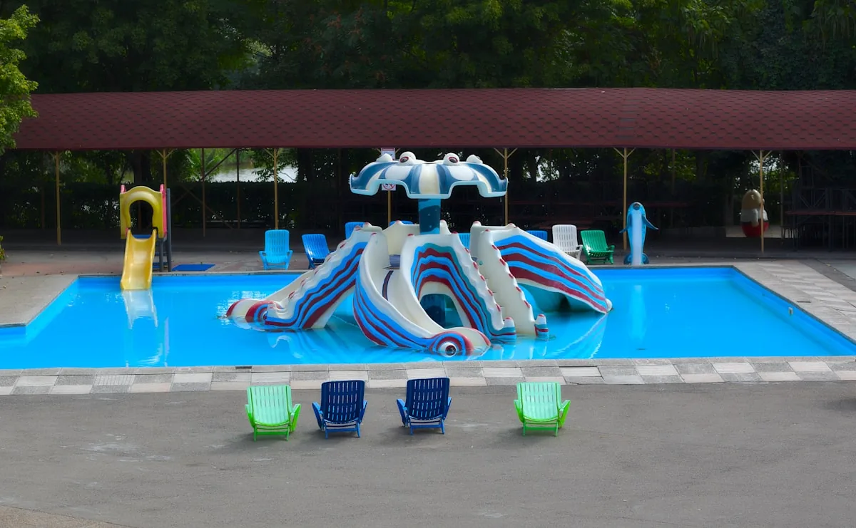 An outdoor swimming pool complex with multiple colourful water slides and lounge chairs, representing the outdoor pool and lazy river facilities available at Haven holiday parks across the UK