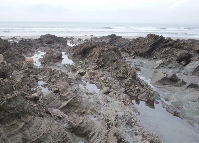 Rocky reef at low tide on Cornwall coast showing exposed rock pools