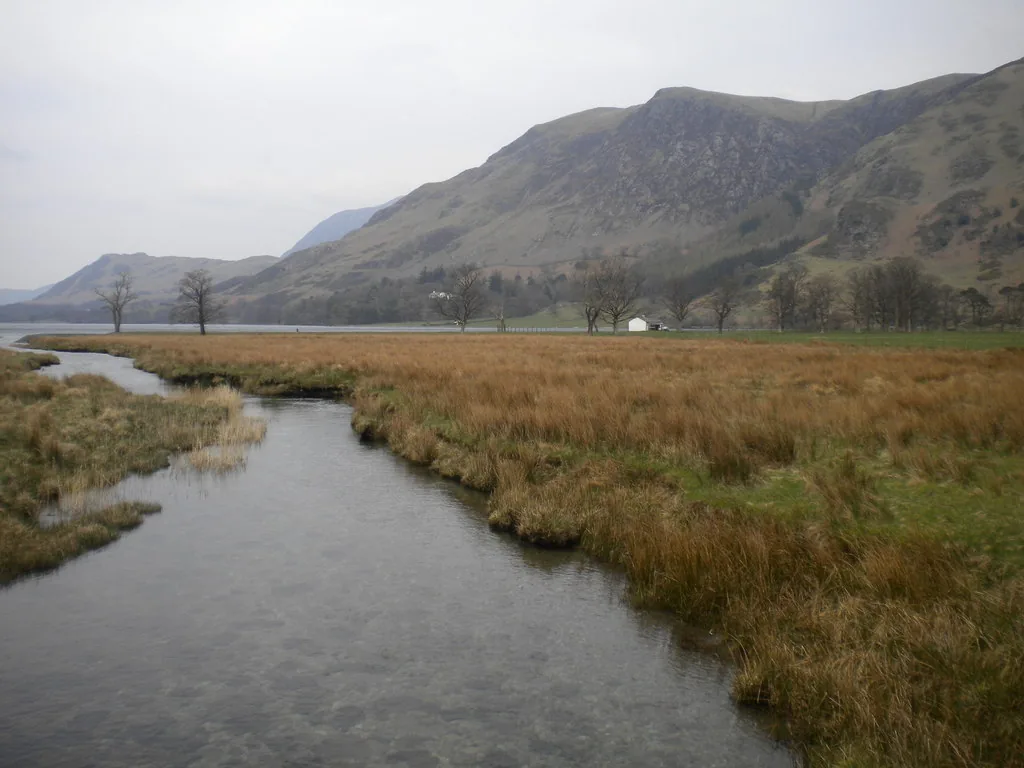Warnscale Beck flowing through marshland toward Buttermere lake, with Fleetwith Pike behind — the approach to Gatesgarth car park