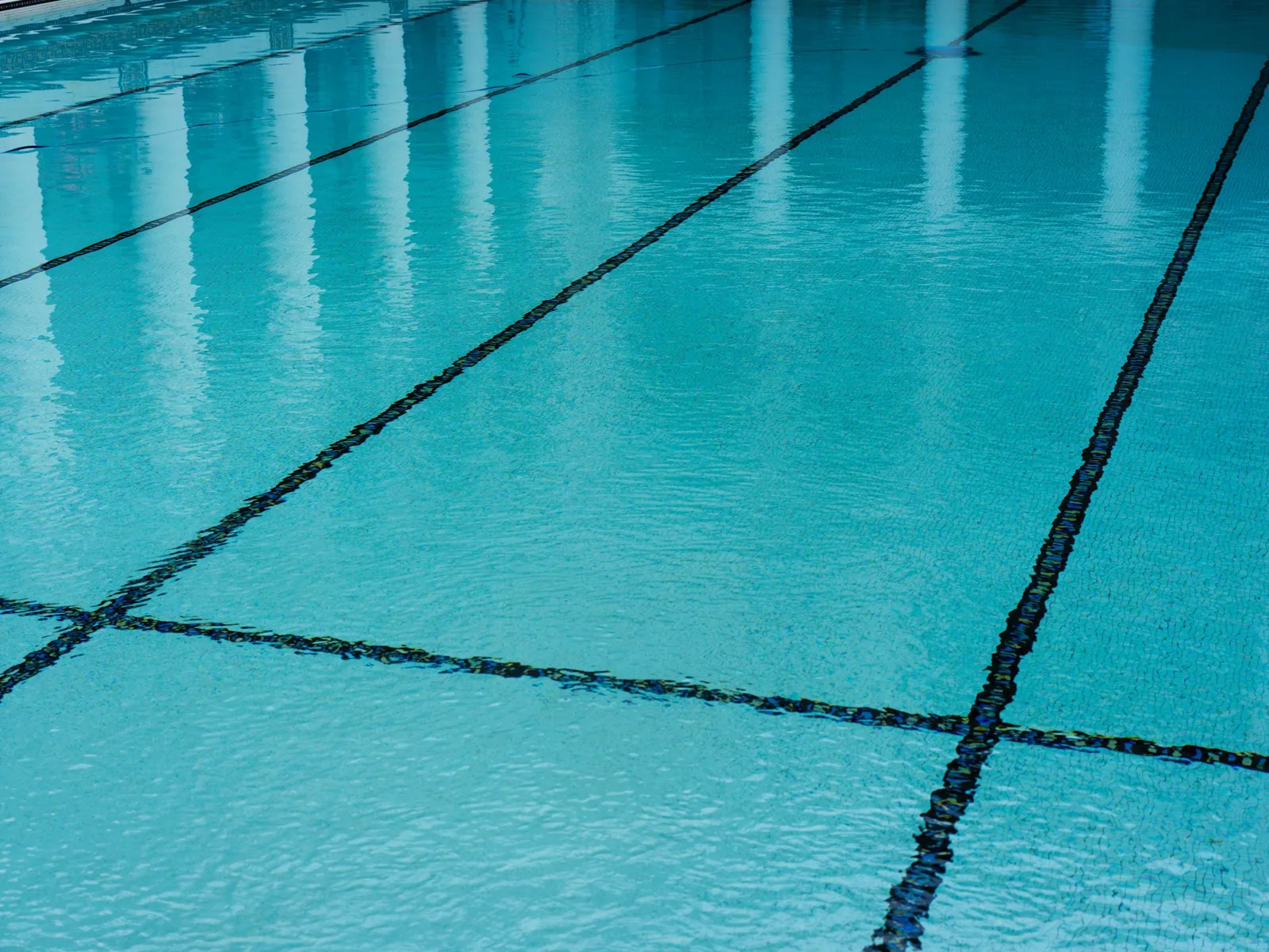 Swimming pool lanes from above showing lane ropes and pool floor, representing pool water clarity