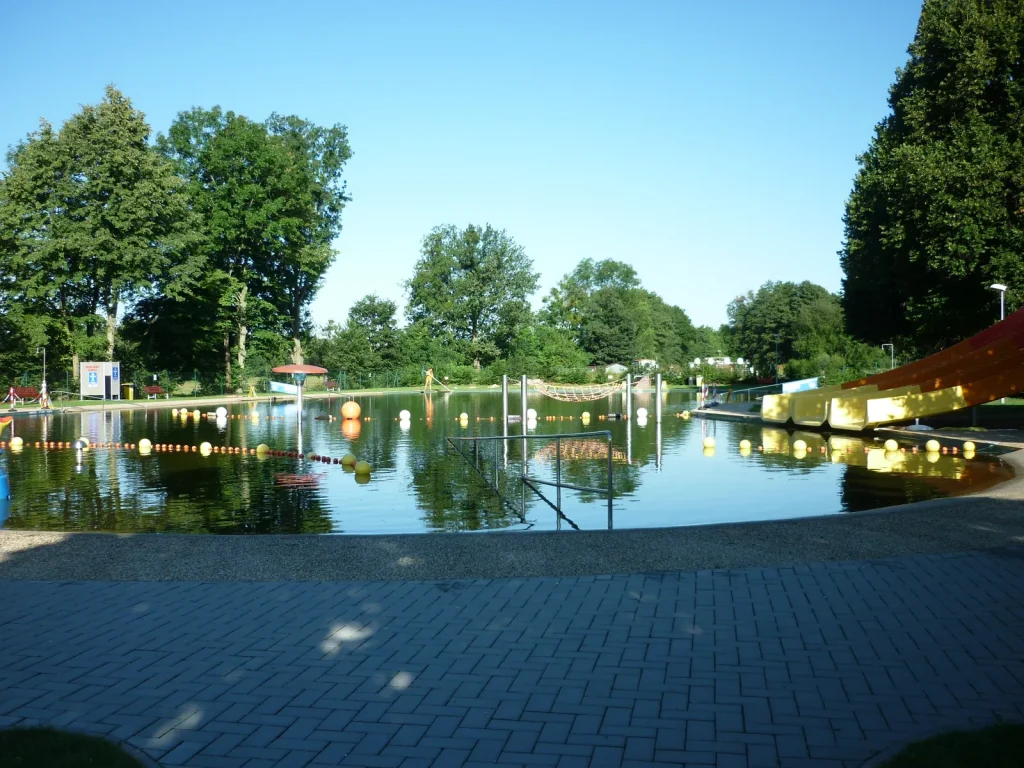 Natural swimming pool biolake at Litovel Czech Republic with lane markers and water slide