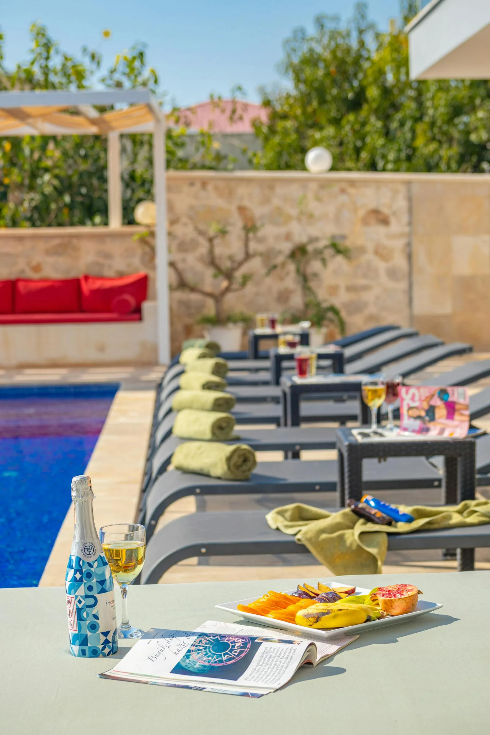 A relaxing poolside scene at a Greek island resort with lounge chairs sun umbrellas clear water and a Mediterranean landscape in the background representing what to expect from swim-up room holidays in Greece