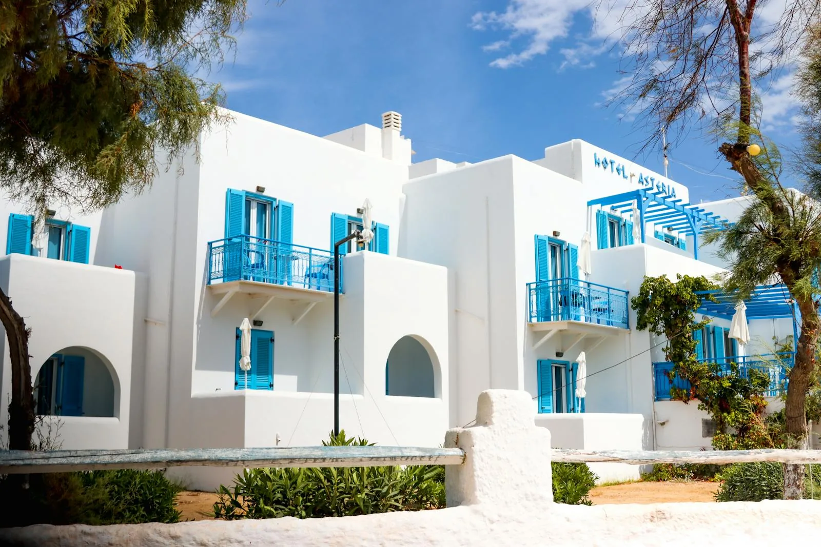 Charming Greek island hotel with blue shutters overlooking Aegean