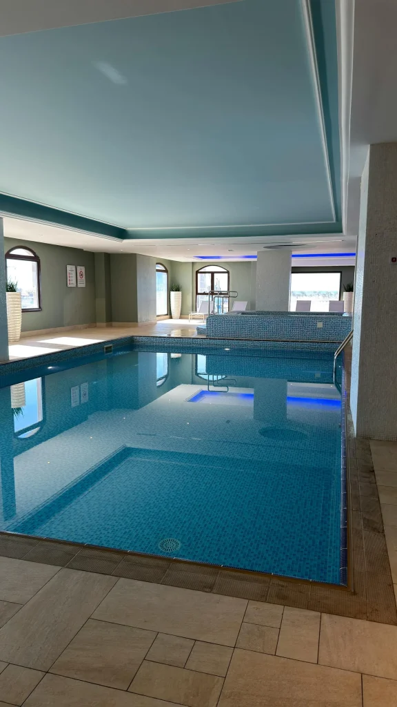 Luxurious indoor spa pool at a UK hotel with blue mosaic tiles and arched windows