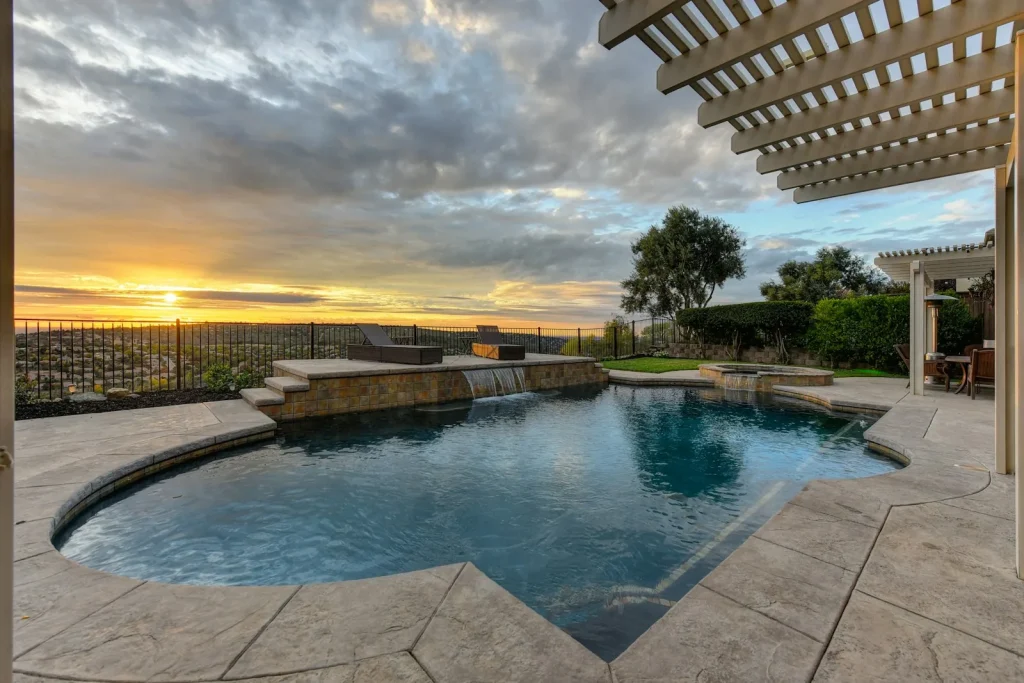 A luxury inground swimming pool with pergola at dusk illustrating UK swimming pool installation costs