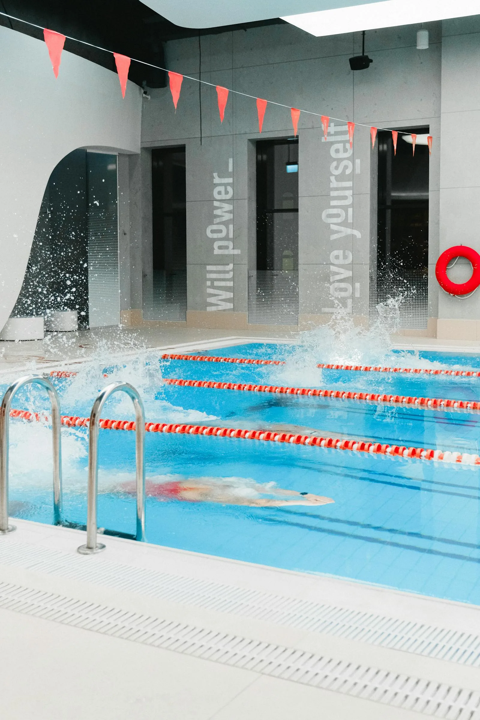 An indoor public leisure centre swimming pool with lane ropes and overhead lighting representing the UK swimming pool sector with 4272 pools across 2896 sites according to Leisure DB 2024 data