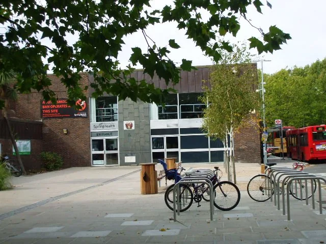 Main entrance and forecourt of Pools on the Park, Richmond, showing the Grade II listed 1966 glazed curtain wall facade with bicycle racks
