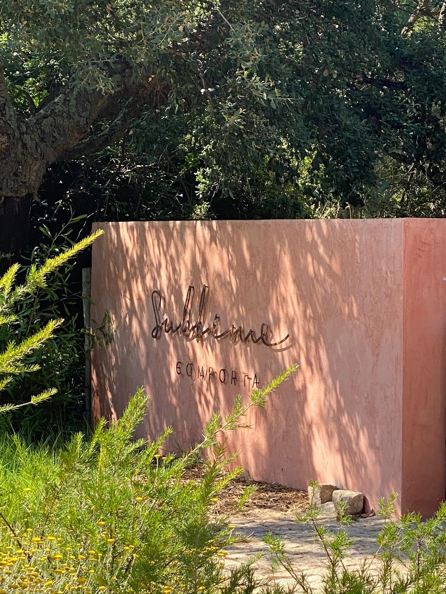 Sublime Comporta resort sign in dappled sunlight with native Portuguese vegetation