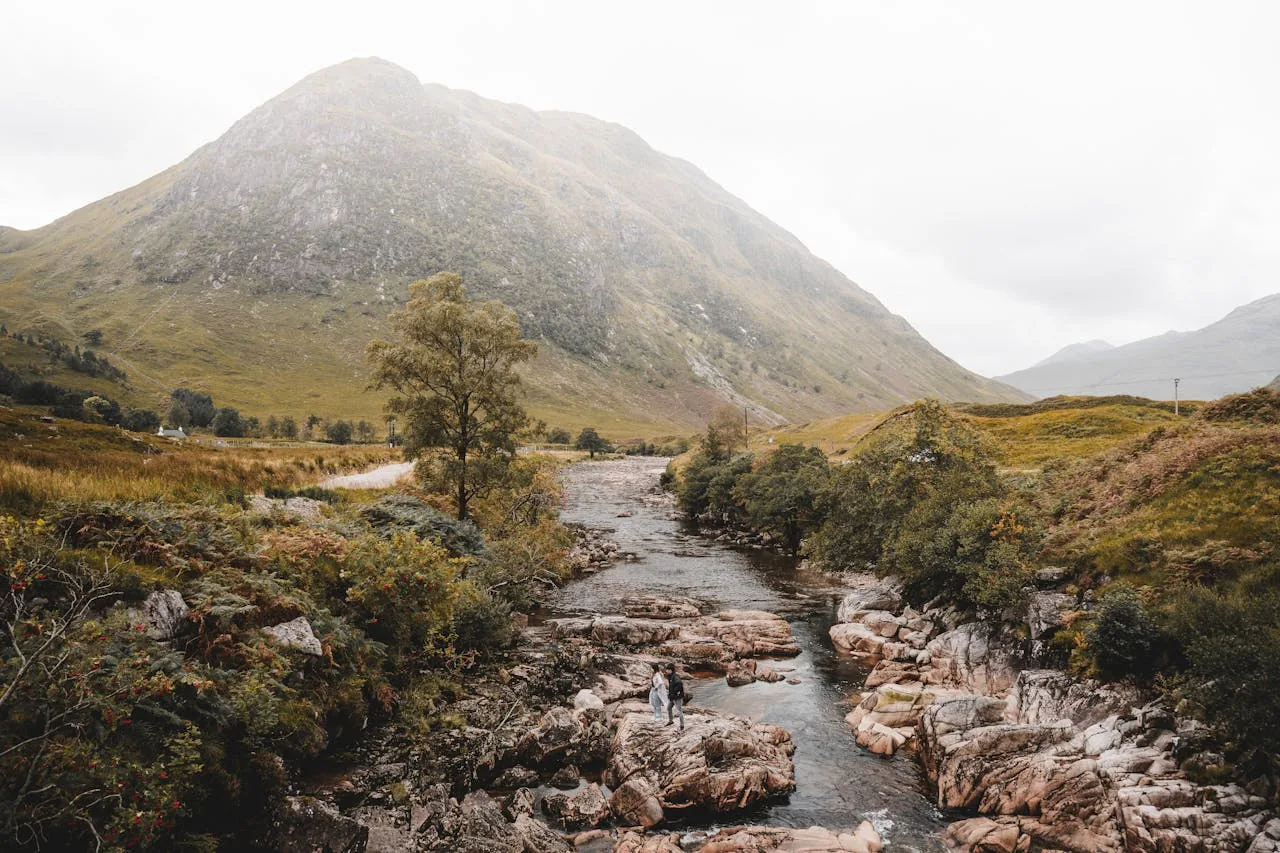A misty atmospheric view of pools and waterfalls in a Scottish highland glen with dramatic cloudy skies representing the legendary history of the Fairy Pools and Scottish wild swimming access rights under the Land Reform Act 2003