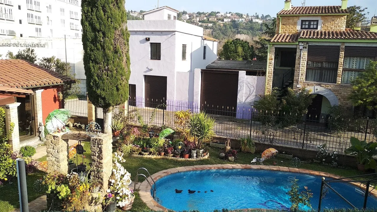 Private residential swimming pool with ornate garden in Girona, Catalonia, showing typical Spanish villa style