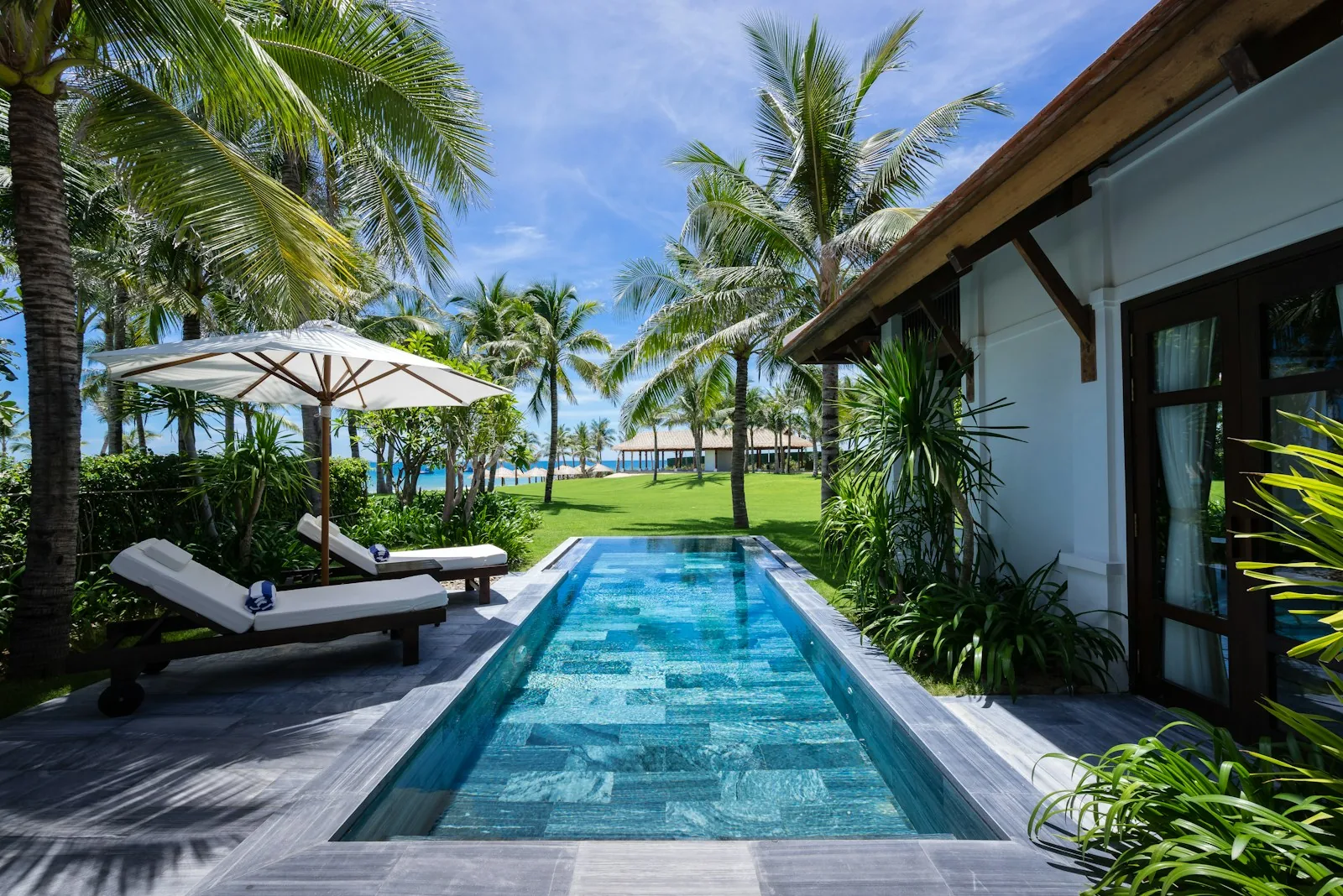Private swimming pool at a holiday villa with sun loungers and palm trees, representing the private pool experience in Spanish holiday rentals