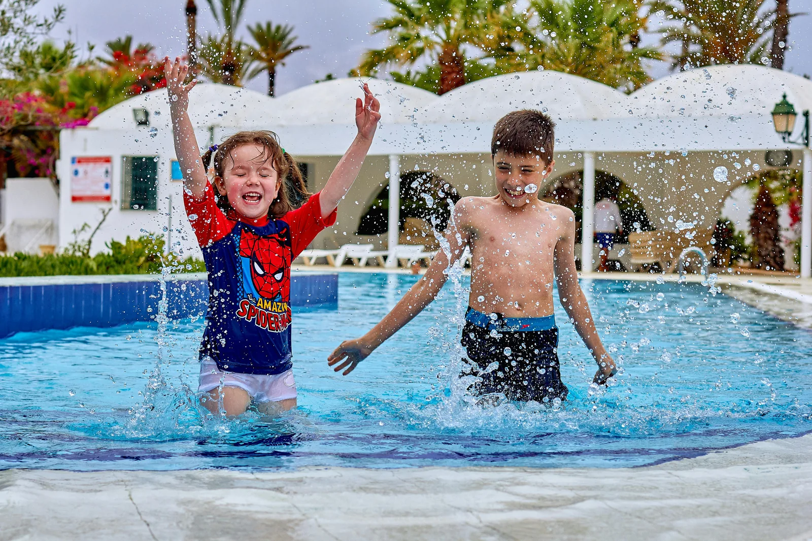 A family enjoying a leisure pool with colourful water slides a wave machine and splash zones at a UK leisure centre representing how to find a swimming pool with slides near me in the UK