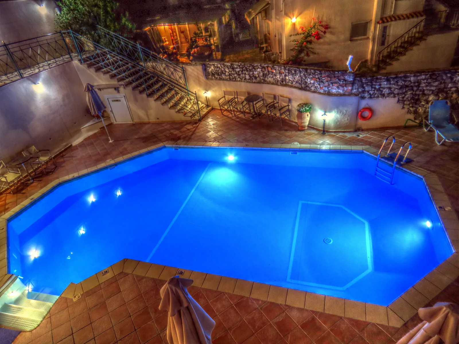 Illuminated octagonal swimming pool at a Greek holiday property near Parga at night