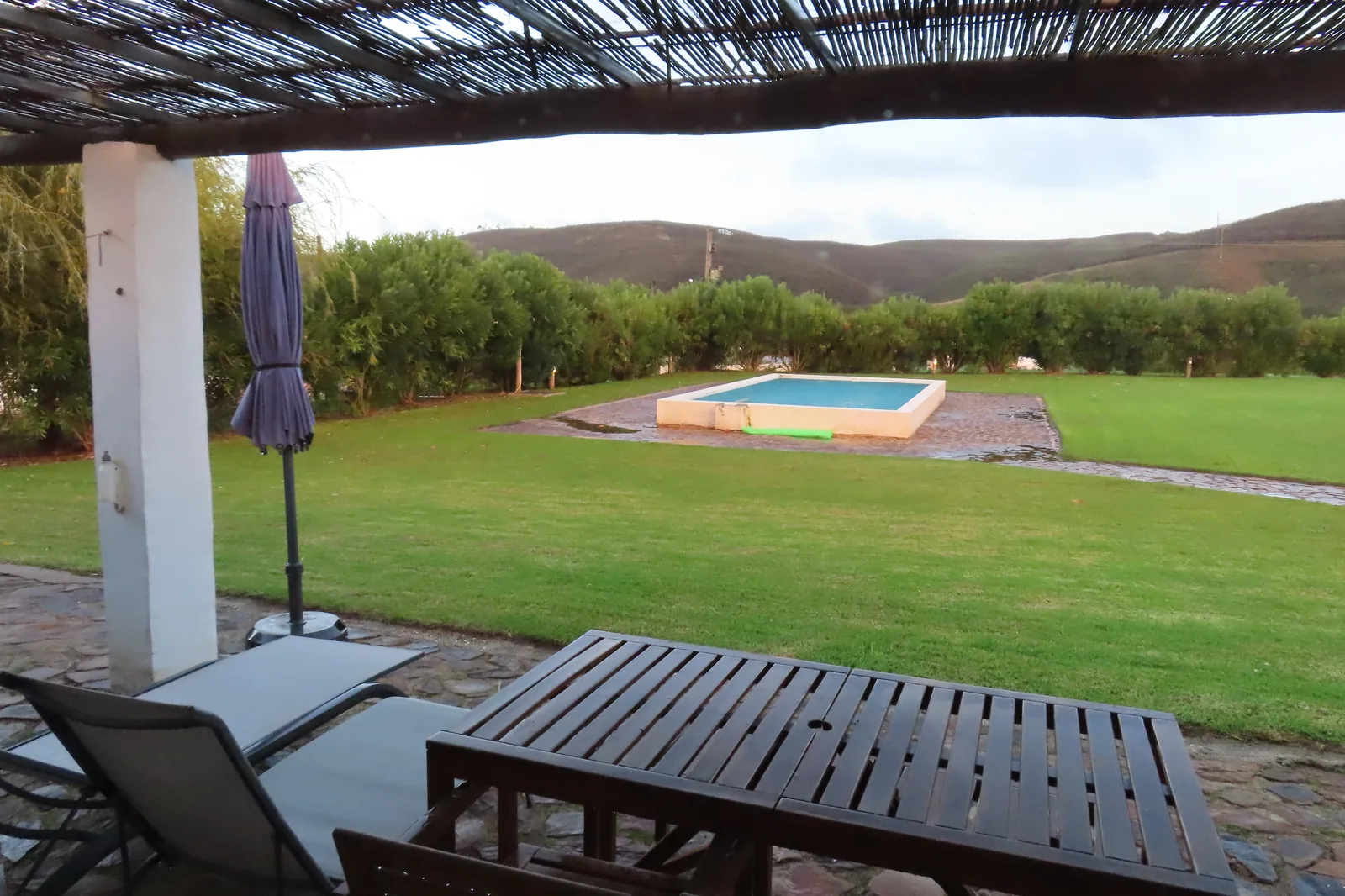 View from covered terrace of a Portuguese holiday villa with private pool and rolling hills in background