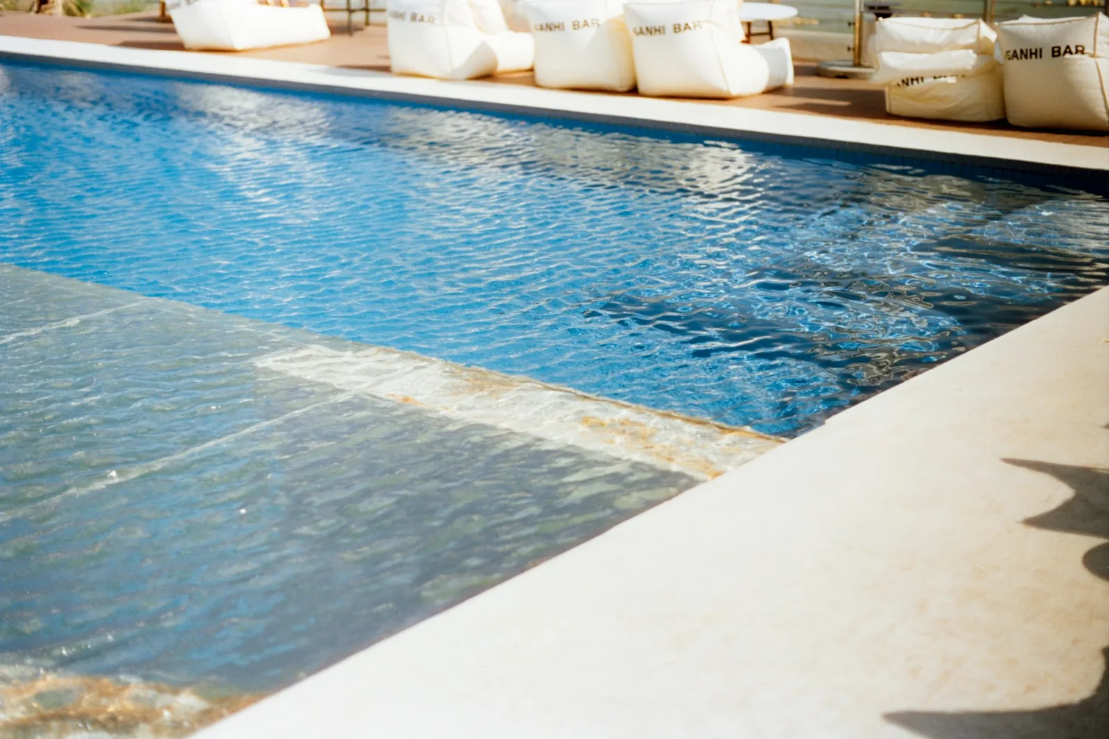 Outdoor swimming pool with clear blue water in a sunny environment