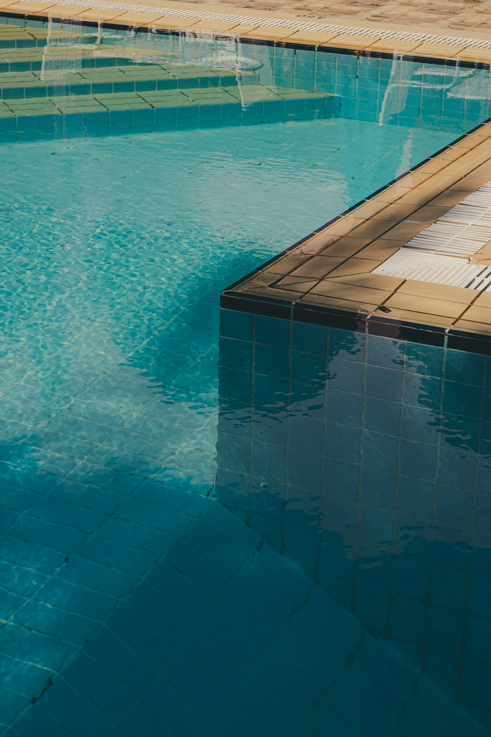 Clear blue swimming pool with tiled floor visible through the water